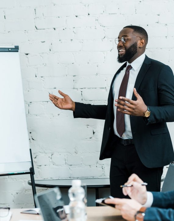 happy african american business coach talking near white board and colleague